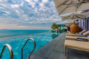 岘港Le Sands Oceanfront Danang Hotel的度假酒店的无边泳池享有大海的景致。