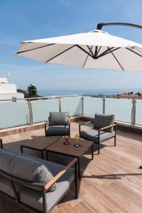杜布罗夫尼克莱拉酒店的庭院配有两把椅子、一张桌子和一把遮阳伞