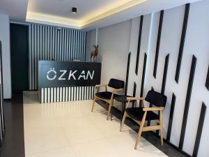 乌宗Ozkan Otel的一间房间,配有两把椅子和墙上的标志