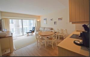 克诺克－海斯特bel appartement à 100m de la plage的厨房以及带桌椅的起居室。
