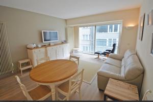 克诺克－海斯特bel appartement à 100m de la plage的客厅配有桌子和沙发