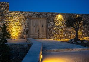 米克诺斯城KK Mykonos Village的石头建筑,晚上有木门