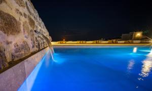 米克诺斯城KK Mykonos Village的夜晚的游泳池,灯光蓝色