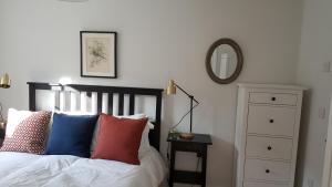 布里斯托The Cottage的一间卧室配有一张带彩色枕头和镜子的床