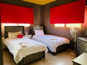 马达巴Laura’s Modern Villa的带红色窗户的客房内的两张床