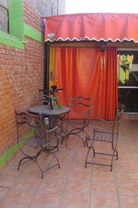 卢汉德库约Intiaconcagua Habitaciones Familiares的露台配有桌椅和红色窗帘