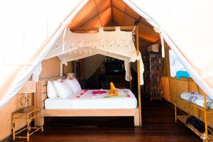 吉利特拉旺安La Cocoteraie Ecolodge - Luxury Glamping Tents的帐篷内一间卧室,配有一张床