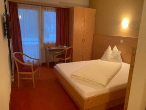 旺斯汪斯公园酒店的酒店客房配有一张床铺、一张桌子和一张书桌。