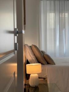 奥尔贝泰洛B&B Il Gabbiano的卧室配有带枕头的床铺和窗户。