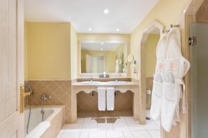 普拉亚布兰卡布兰科大卡斯蒂略塔格罗酒店的带浴缸、水槽和镜子的浴室