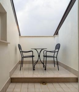 Bagnoli del Trigno多莫斯酒店的楼梯箱里两把椅子和一张桌子
