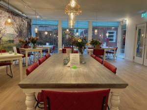 埃尔斯特温馨住宿加早餐旅馆的餐厅里一张大木桌,配有红色椅子