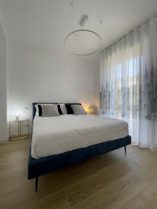 奥尔贝泰洛B&B Il Gabbiano的白色的卧室设有一张大床和一个大窗户
