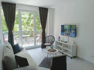 大格拉迪什泰Apartman 3N的带沙发和电视的客厅以及阳台。