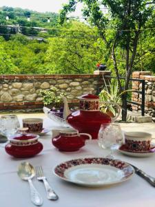 西格纳吉Guest house Babaka的一张桌子,上面放着红色的菜肴和茶壶