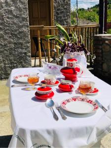 西格纳吉Guest house Babaka的一张桌子上放有红白板和银器