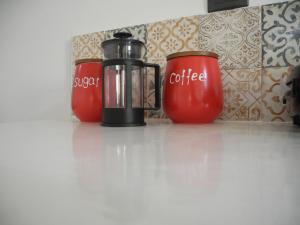 Éxo GoniáMagma & Tefra的两个红咖啡杯坐在柜台上