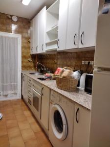 纳瓦尔卡内罗Piso a 20 minutos del centro Madrid con wifi的厨房配有白色橱柜、洗衣机和烘干机