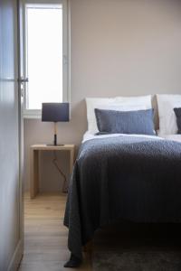 锡尔卡Levin Kunkku B1的一间卧室配有一张带蓝色毯子的床和窗户。