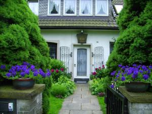 代斯特尔山麓巴德明德尔Gästehaus Villa Kreativ Susanne Lay的前面有鲜花的白色房子