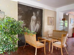 奈达Hotel Jurate的客厅配有桌椅和绘画作品