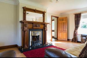 LetterbreenCorraglass House - close proximity to Cuilcagh的客厅设有壁炉和镜子