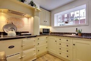 南安普敦10 Westgate Street Southampton的厨房配有白色橱柜和窗户。