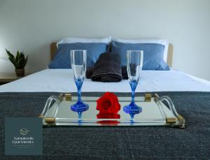 尼亚米卡尼奥纳Samakovlis Apartments的床上的托盘,上面放着两杯酒和玫瑰