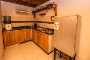 圣佩德罗·德·阿塔卡马Hotel Parina Atacama的厨房配有木制橱柜和不锈钢冰箱。
