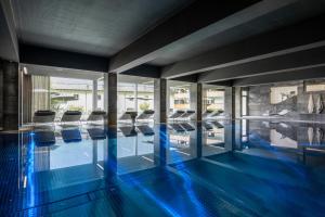 加舒恩斯维里塔蒙塔峰体育酒店的拥有蓝色地板和玻璃墙的游泳池