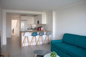 滨海卡涅Appartement rénové, terrasse vue mer的一间带蓝色沙发的客厅和一间厨房