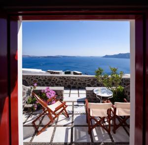 伊亚尼科斯别墅酒店的享有带椅子和桌子的庭院的景色。