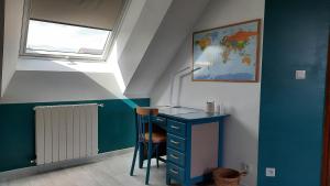 MaignéLa Ménagerie的客房设有蓝色的办公桌和窗户。