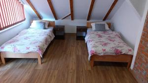 Dubrave GornjeApartments Alibasic的铺有木地板的小客房内的两张床