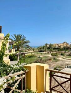 艾因苏赫纳A sea view spacious cheering 5 bedroom villa Ain Sokhna "Ain Bay" فيلا كاملة للإيجار قرية العين باي的一座黄色的建筑,有栅栏,还有一片树木林立的田野