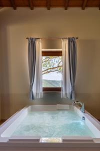奥维多Antichi Casali di Charme的浴室设有大型浴缸和窗户。