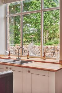 阿普比Plum Cottage的厨房设有水槽和窗户。