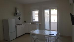 普尔萨诺Casette EOS e ZEFIRO的厨房配有桌子和白色冰箱。