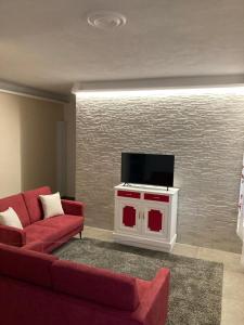 多尔切阿夸La Tillanzia的客厅配有红色沙发和平面电视