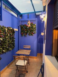 莫利纳德塞古拉Apartamento El Azul的蓝墙,带桌子和椅子,植物