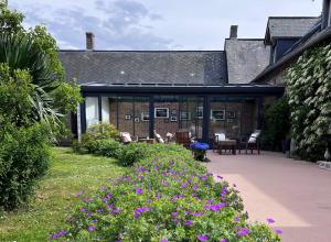 Sotteville-sur-MerLe Pré Marin的一座花园,在一座建筑前种有紫色花卉