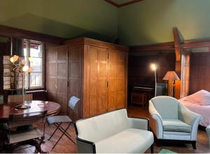 吉维尼L'Atelier du Paysagiste - maison d'artiste的卧室配有1张床、1张桌子和1把椅子