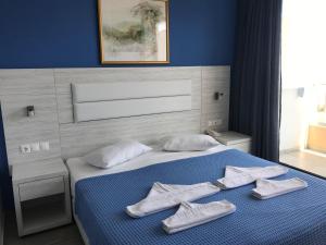 古瓦伊蓝色爱琴海套房公寓式酒店的一间卧室配有一张带白色毛巾的床