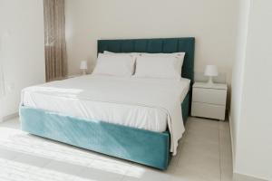 尼亚·卡利克拉提亚BLUE AND WHITE LUXURY suites的一间卧室配有一张大床和蓝色床头板