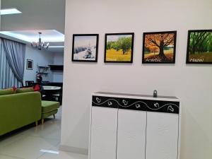 峇都丁宜Pearl Residences Sleep 27的客厅配有绿色沙发和墙上的照片