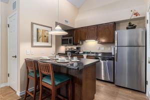 埃尔帕索Chase Suite El Paso的厨房配有不锈钢冰箱和木制橱柜