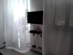 利沃诺Casina del porto的电视,坐在带窗帘的房间