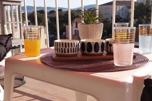 土伦Le Doux voyage T3, vue Mer, Wi Fi, PARKING gratuit的阳台上的桌子和四杯啤酒