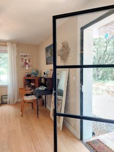 PujautDomaine Colibri en Provence的一间带玻璃门和书桌的客厅