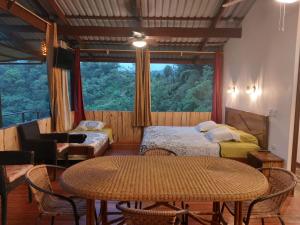 奎波斯城Santa Juana Lodge & Nature Reserve的客房设有桌子、床和窗户。